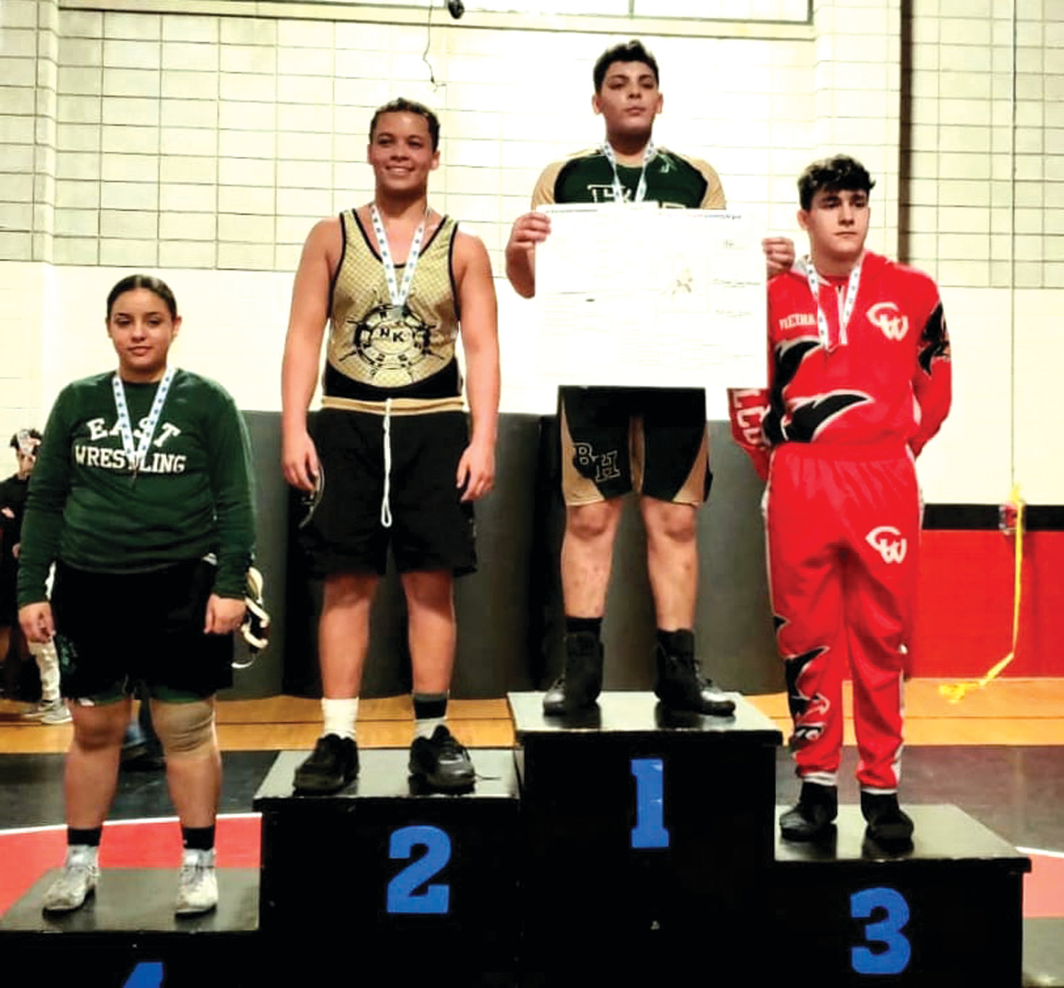 PROLIFIC PERFORMER: Johnston resident and Bishop Hendricken freshman Michael Camarena (third left) stands atop the Olympic-style platform inside Coventry High’s C. Arthur Flori Gymnasium where he won both the freshman and junior varsity state championships. He’s joined by Alexis Franco, fourth place Cranston East; Malcolm Lima, runner-up from NK; and David Vieira, Cranston West.